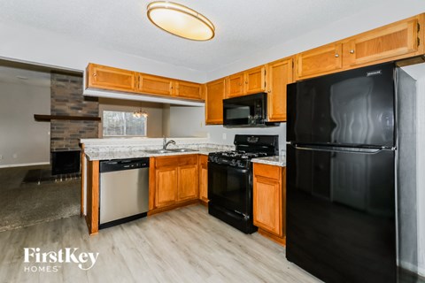 A kitchen with wooden cabinets and black appliances.