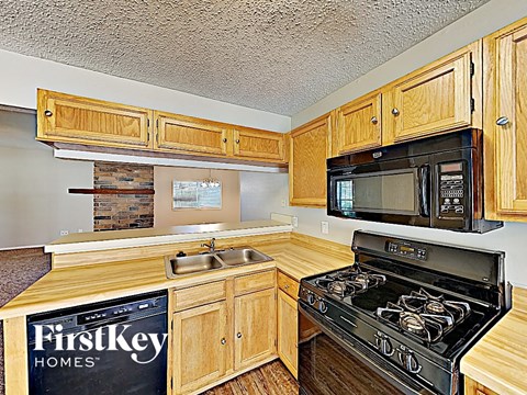 A kitchen with wooden cabinets and a black stove top oven.
