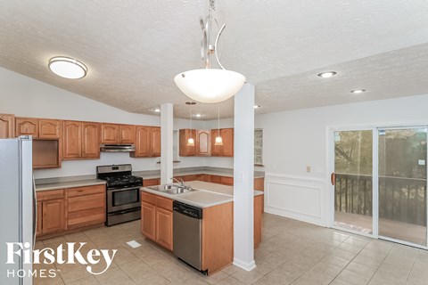 A kitchen with wooden cabinets and a white fridge is on the market.