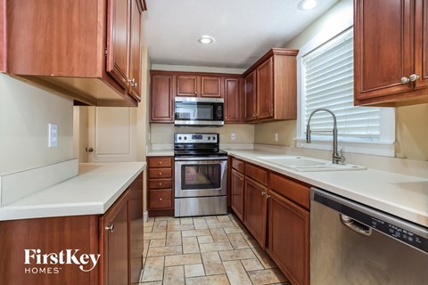 A kitchen with wooden cabinets and a stainless steel dishwasher.
