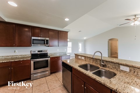 A kitchen with brown cabinets and granite countertops.