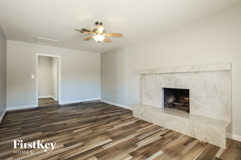 a living room with a fireplace and a ceiling fan