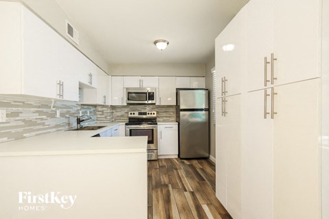 a modern kitchen with white cabinets and stainless steel appliances