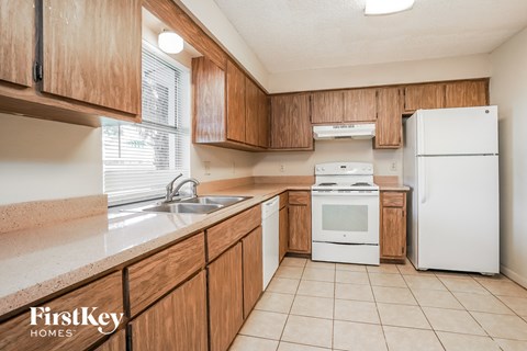 A kitchen with wooden cabinets and white appliances.