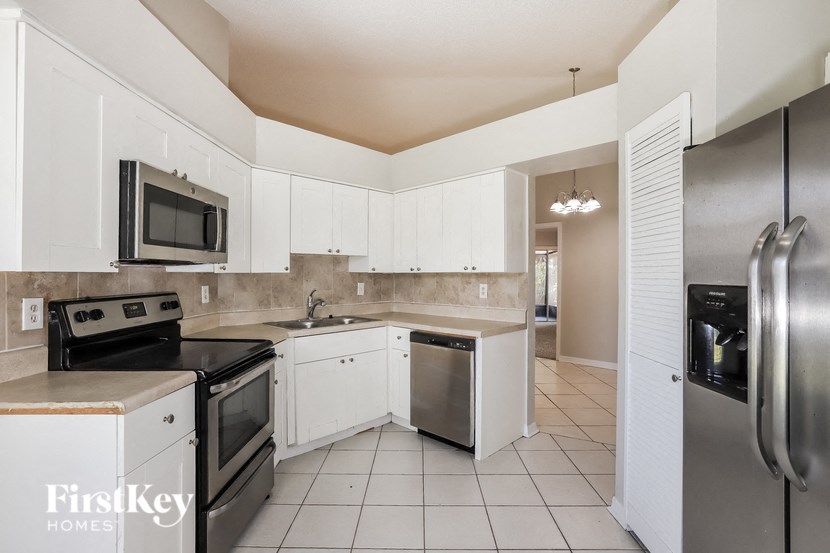 a kitchen with stainless steel appliances and white cabinets