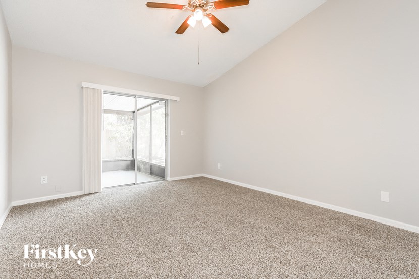 a empty living room with a ceiling fan