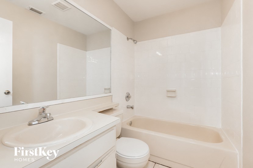 a white bathroom with a tub and a sink and a toilet