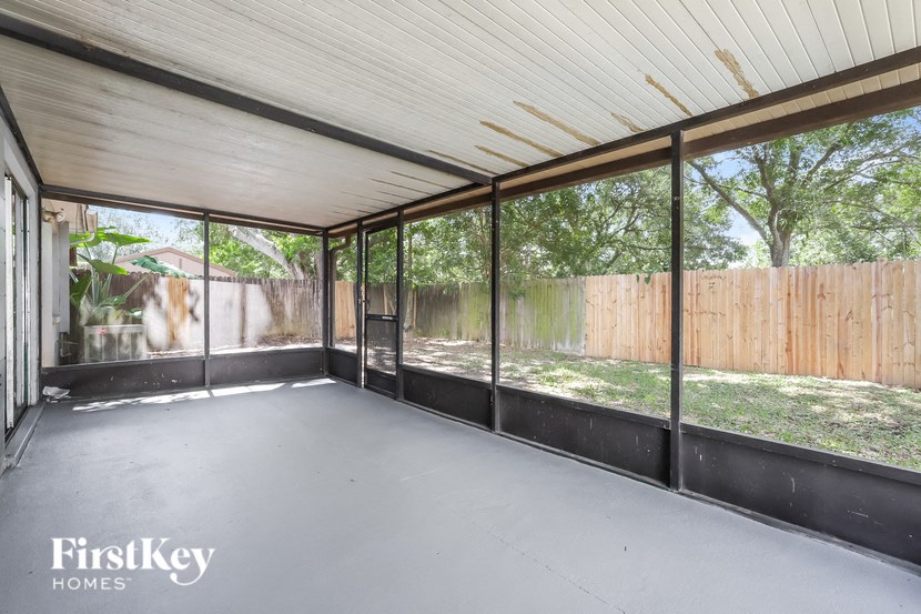a room with glass windows and a fenced in yard