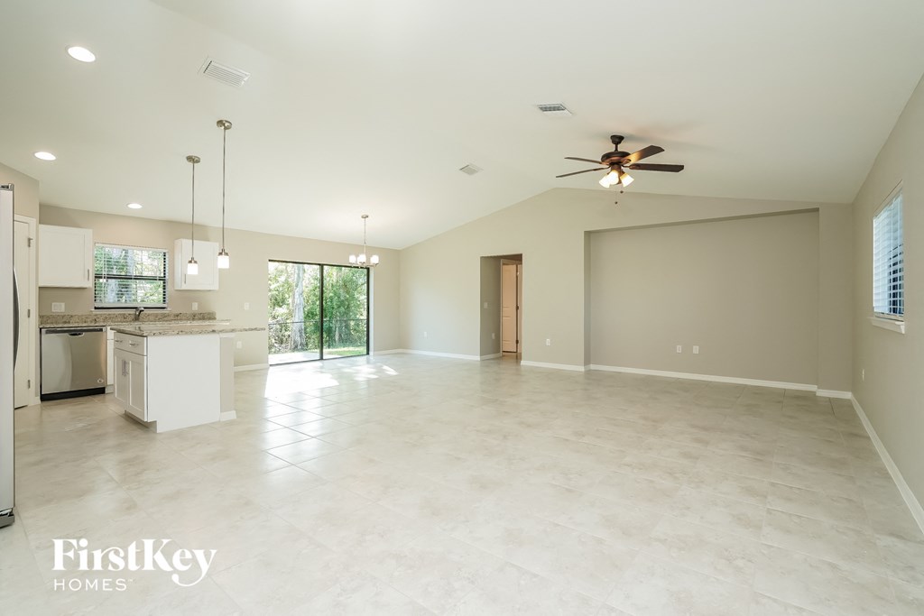 an empty kitchen and living room with a ceiling fan