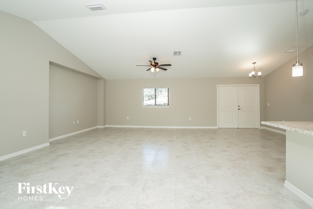 an empty kitchen and living room with a ceiling fan