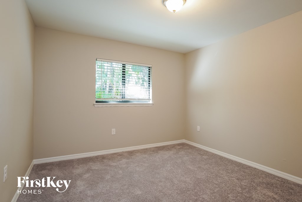 a spacious room with carpet and a window