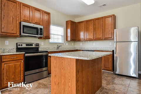 a kitchen with wooden cabinets and stainless steel appliances