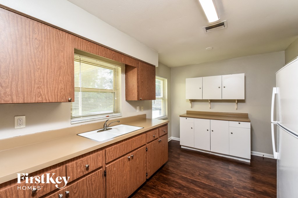 A kitchen with wooden cabinets and a white fridge.