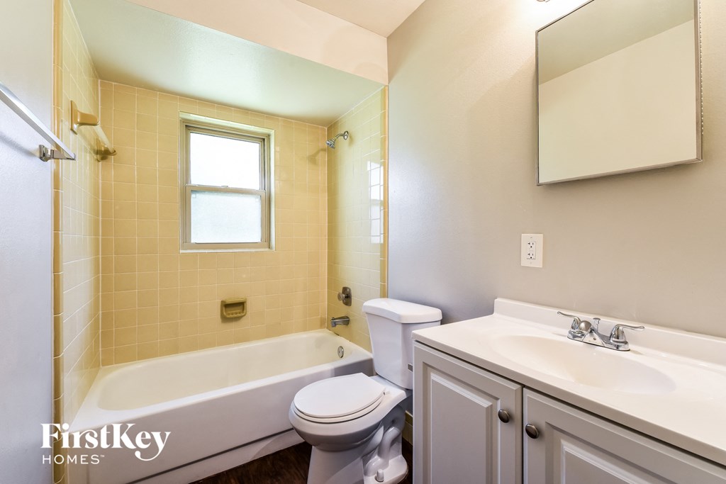 A bathroom with a tub, toilet, and sink.