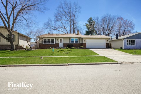 a home with a lawn and a white garage door