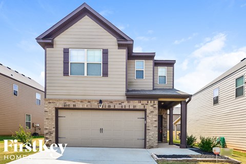 a tan house with a garage door in front of it