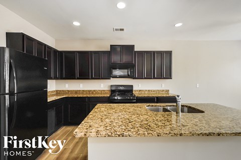 a kitchen with black appliances and granite counter tops