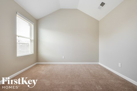 a bedroom with a carpeted floor and a window
