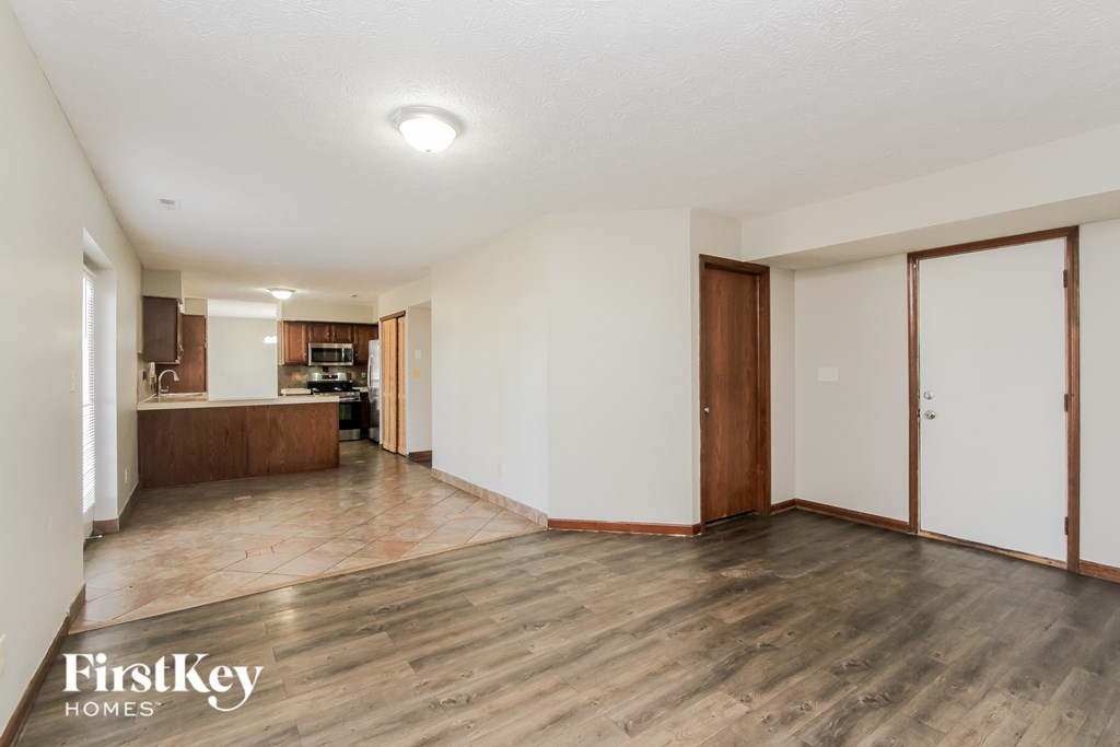 A spacious room with wooden floors and white walls.