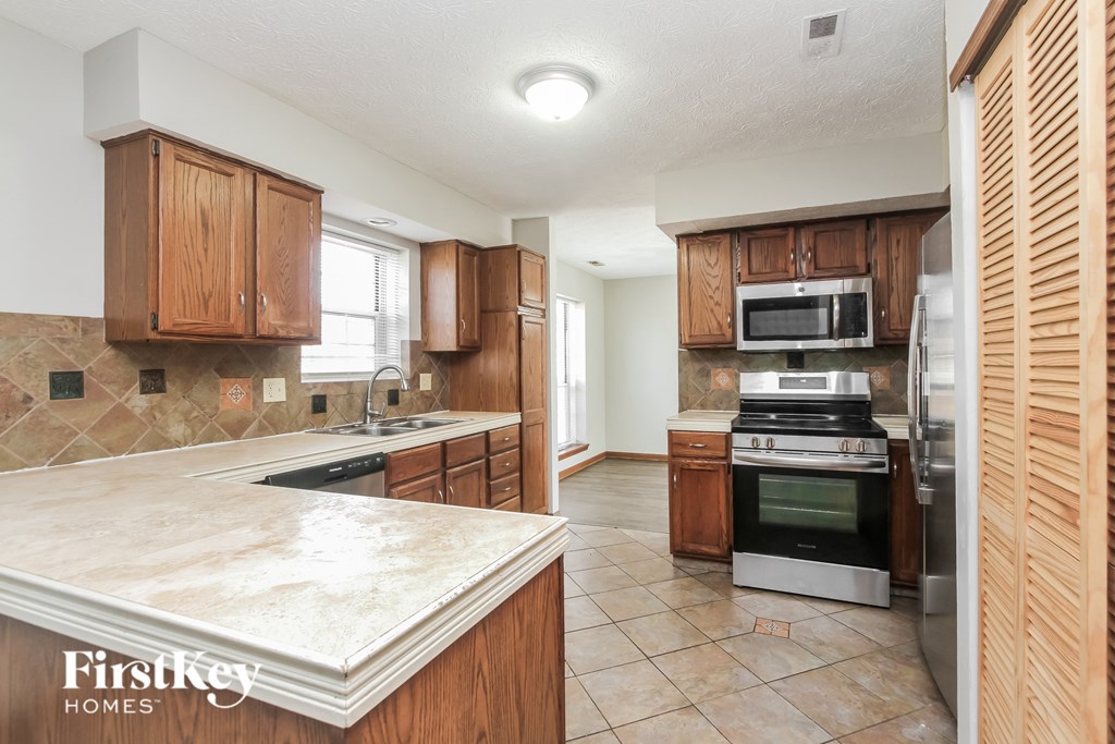 A kitchen with wooden cabinets and a marble countertop.