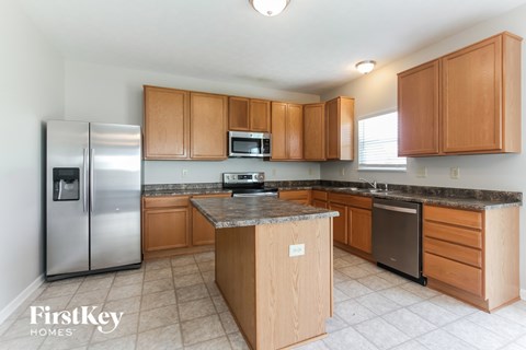 A kitchen with wooden cabinets and a stainless steel refrigerator.