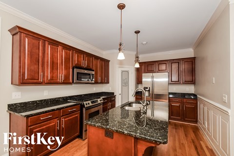 A kitchen with wooden cabinets and a granite countertop.