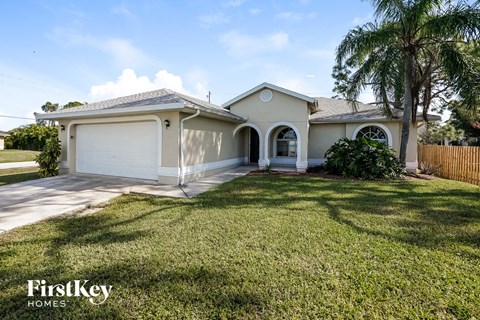 a house with a lawn and a palm tree