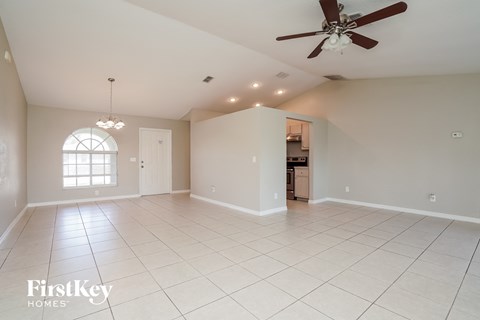 an empty living room with a ceiling fan