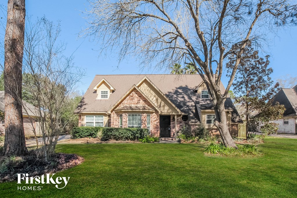 a home with a lawn and trees in front of it