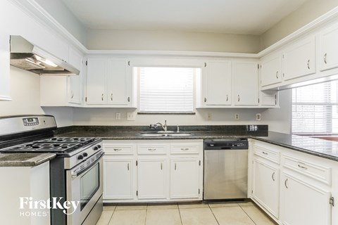 a white kitchen with stainless steel appliances and white cabinets