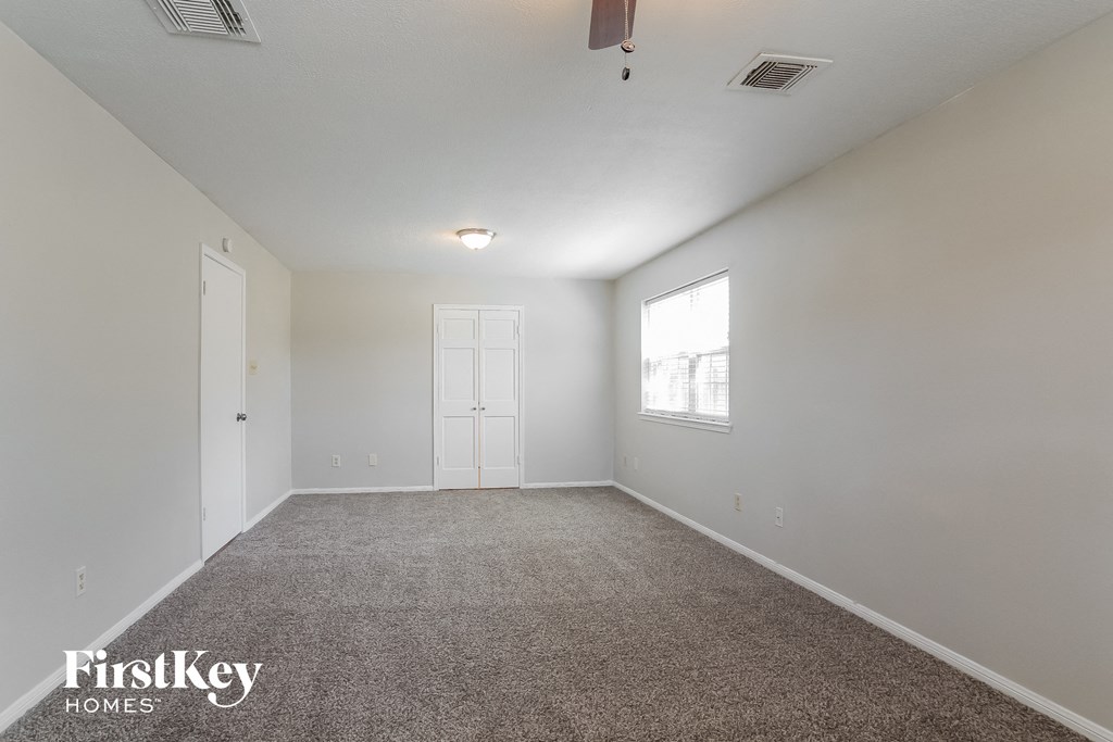 a spacious living room with carpet and a window