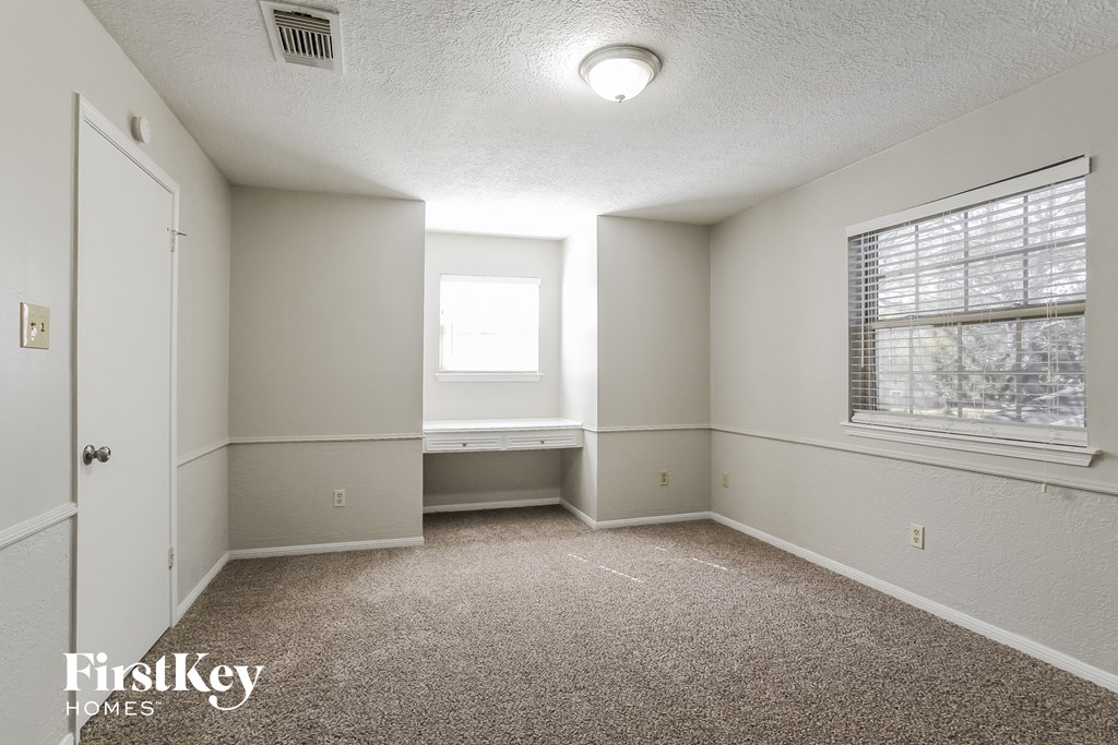 an empty room with carpet and a window