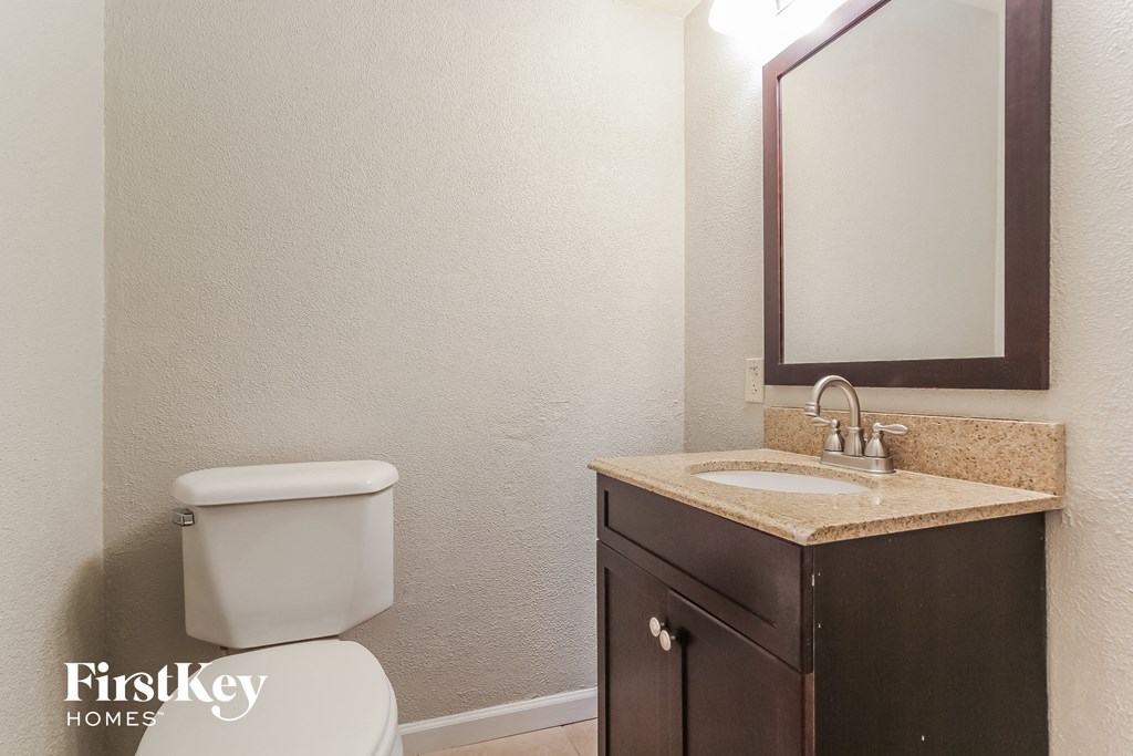 a bathroom with a toilet and a sink and a mirror