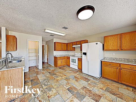 A kitchen with wooden cabinets and a tiled floor.