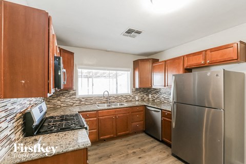 a kitchen with wooden cabinets and stainless steel appliances