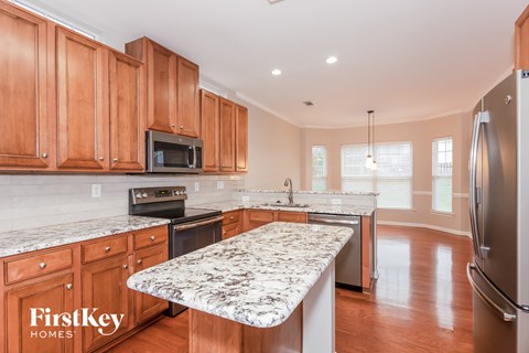 A kitchen with wooden cabinets and a marble countertop.