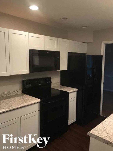 a kitchen with black appliances and white cabinets