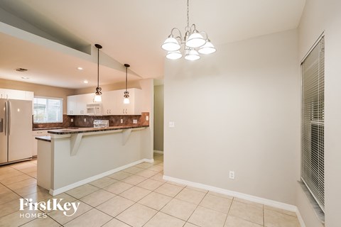 a kitchen and dining room with a counter and a refrigerator
