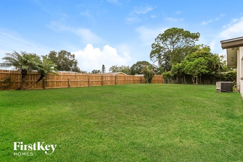 A backyard with a fence and trees.