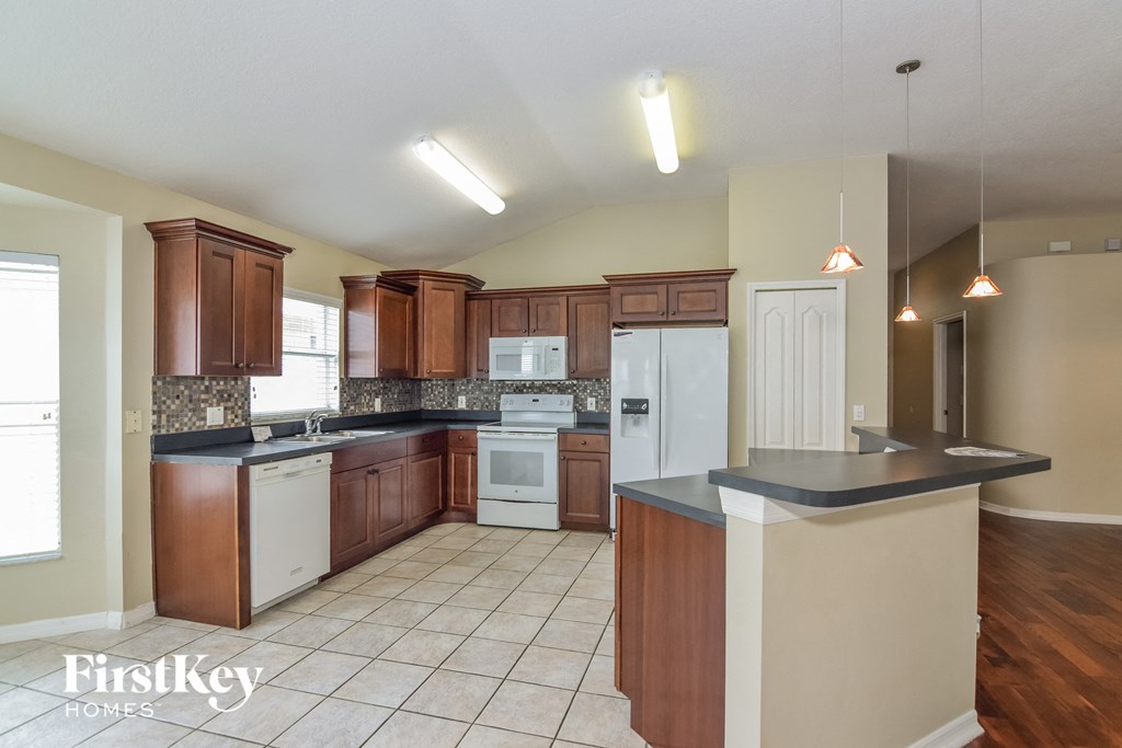 a kitchen with white appliances and wooden cabinets