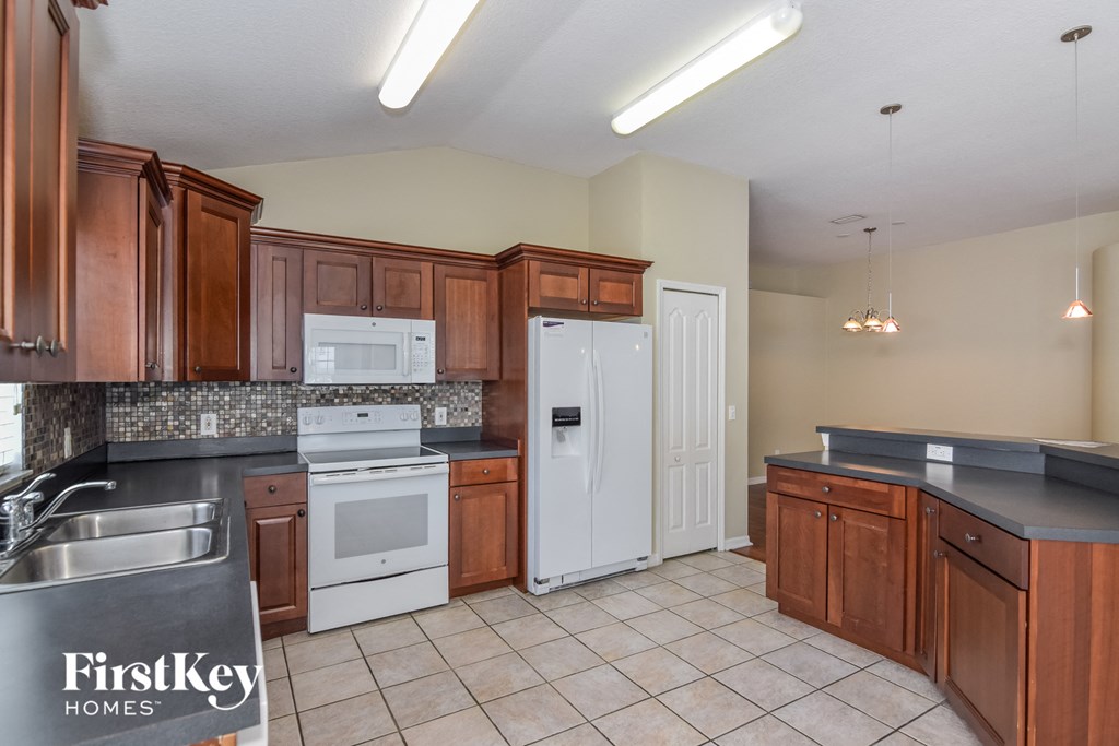 a kitchen with white appliances and wooden cabinets