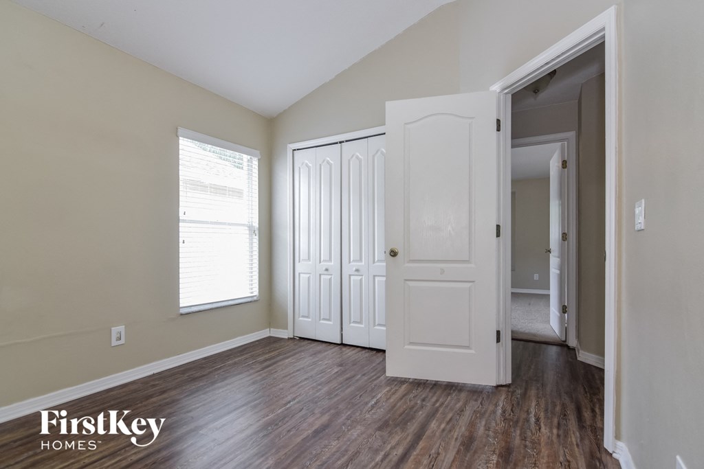 the living room of an apartment with wood floors and white doors