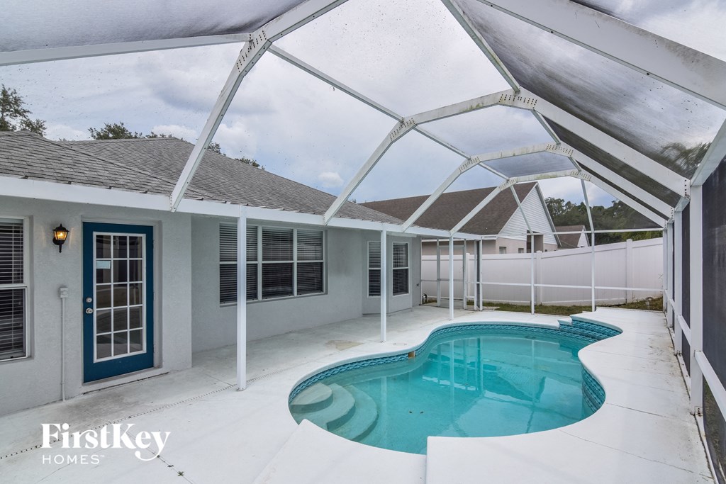 a patio with a pool and a house with a porch