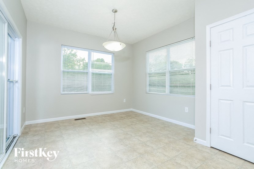 A room with a white door and a window with blinds.
