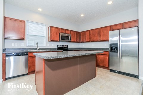 A kitchen with brown cabinets and a white counter top.