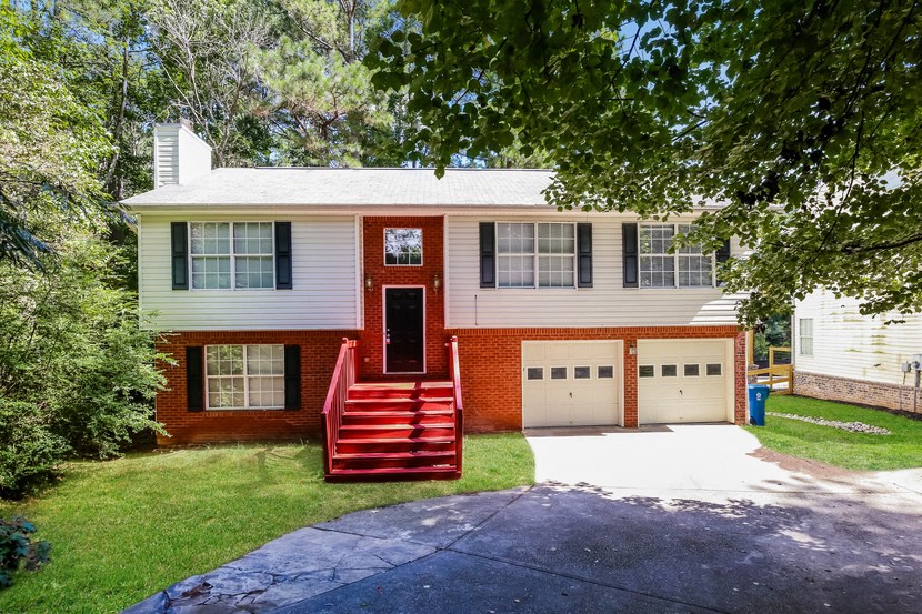 A red and white house with a red front door and steps.