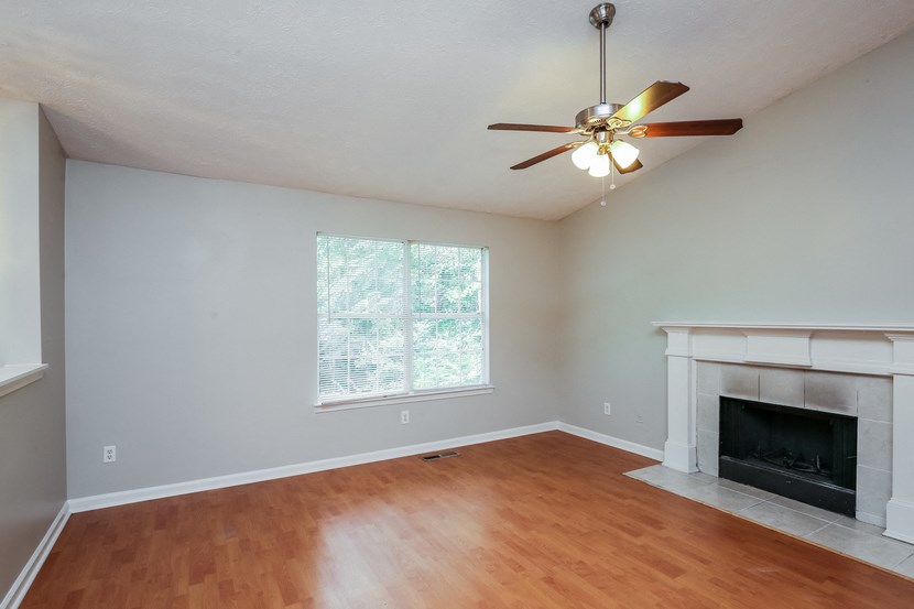 A room with a fireplace and a ceiling fan.