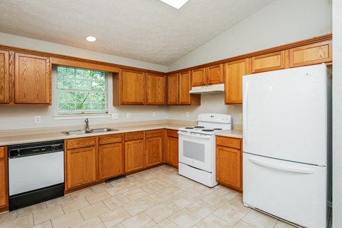 A kitchen with wooden cabinets and white appliances.