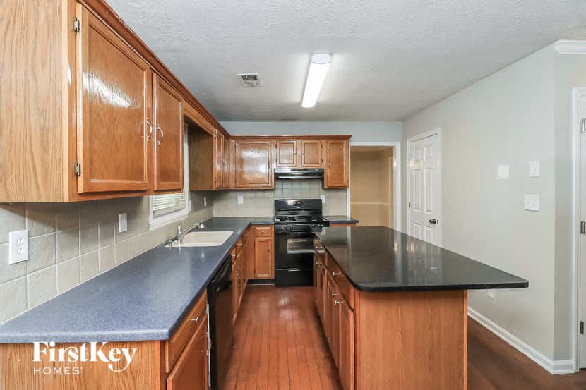 a kitchen with wood cabinets and black counter tops