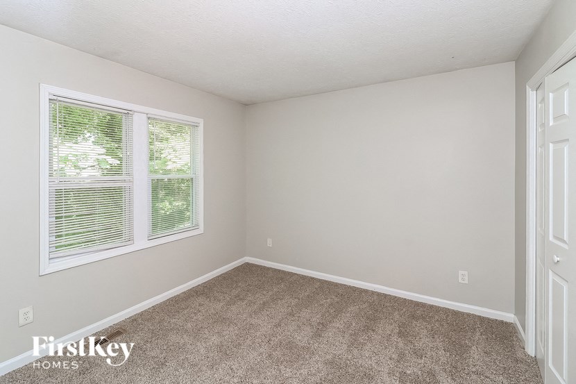 a bedroom with a carpeted floor and two windows
